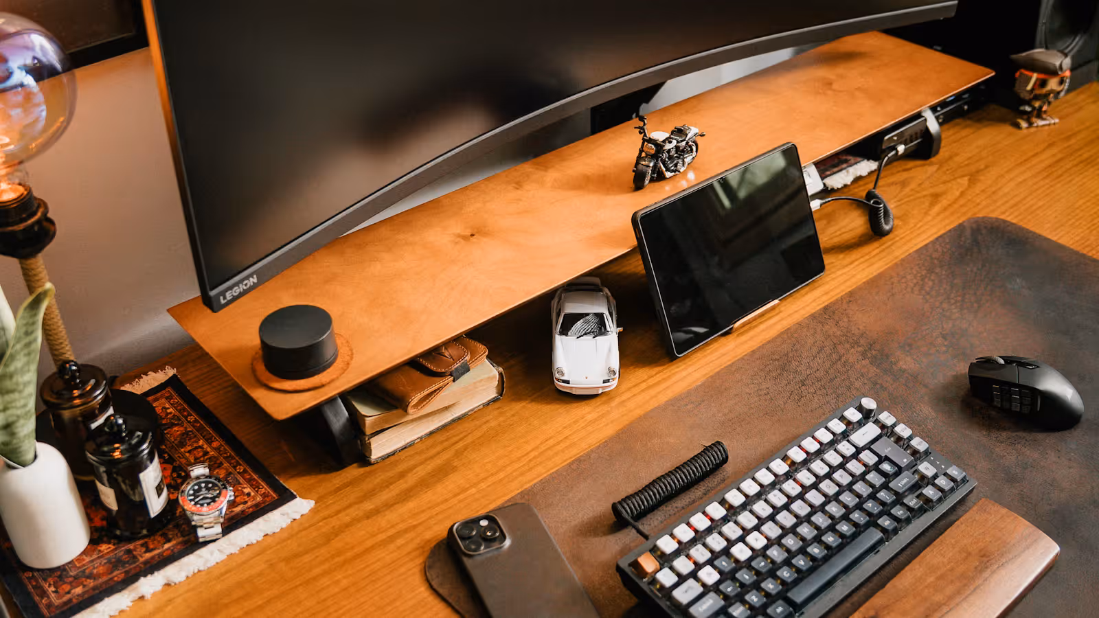 Side view of a curved monitor setup with keyboard and phone on the desk